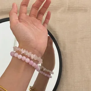 Detailansicht von handgefertigten rosa Natursteinperlen-Armbändern am Handgelenk.