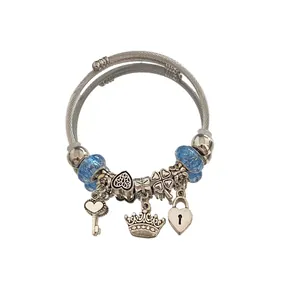 Silver charm bracelet with heart crown and key pendants, featuring blue glass beads.