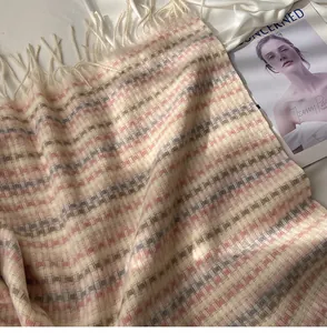 Gros plan détaillé d'une écharpe douillette à carreaux colorés et franges style cachemire.
