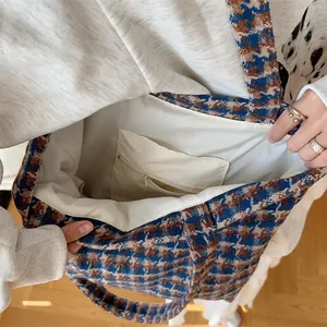 Interior detail of houndstooth woolen tote bag with zipper pocket and white lining.