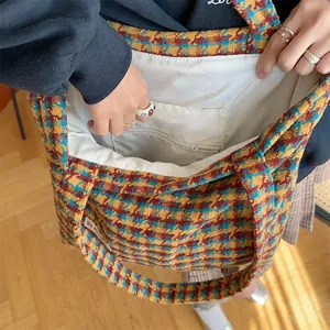 Detailed view of the houndstooth tweed tote bag interior, showing quality lining and pocket.