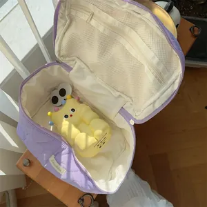 Quilted purple cosmetic bag detail showing large capacity interior and cute yellow toy.