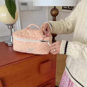 Detail view of the quilted cosmetic bag with heart pattern and zipper, ideal for daily use.