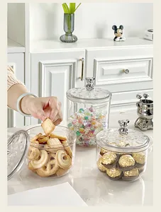 Vue détaillée de bocaux de rangement transparents avec poignées d'ours argentées pour biscuits.
