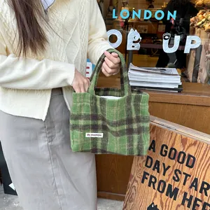 Green plaid wool tote bag detail view, retro pattern fabric, casual aesthetic accessory.