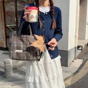 Detailed close up of retro plaid woolen handbag, stylish brown autumn winter daily accessory.
