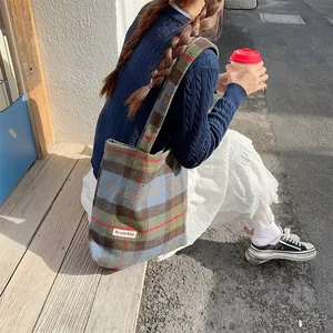 Detail view of the autumn winter vintage wool plaid tote shoulder bag in outdoor lifestyle scene.
