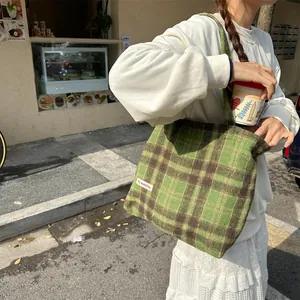 Detailed view of the vintage green plaid woolen tote bag, showcasing textured fabric and sturdy straps.
