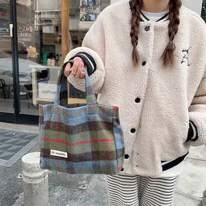 Detailed view of vintage plaid wool handbag, stylish tote bag with soft fabric and durable handle.