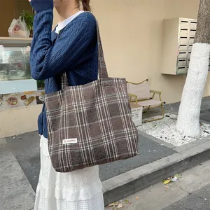 Detail shot of retro woolen plaid tote bag, stylish shoulder bag for autumn and winter daily wear.