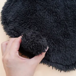 Black fluffy plush pet costume detail, soft textured material for funny puppy apparel.