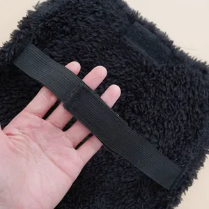 Black fluffy pet costume detail showcasing elastic strap and secure velcro closure design.