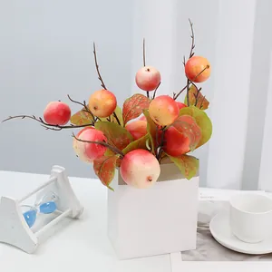 Vue détaillée de branches de fruits artificiels dans un contenant blanc, idéal pour la déco de table.