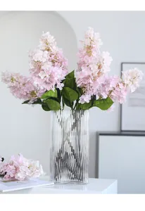 Fiori di ortensia rosa artificiali con vaso in vetro scanalato per decorazione casa.