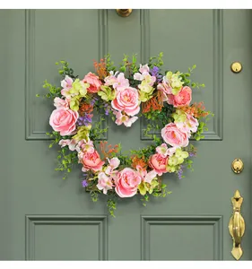 Heart shaped artificial rose flower wreath detail closeup for hanging wedding party home decor.