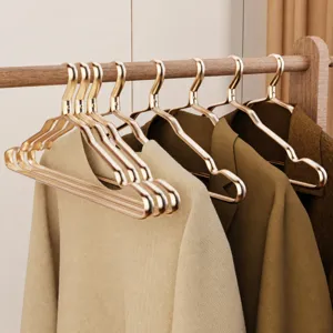 Gold aluminum clothes hangers with non-slip wide shoulder arc design for seamless garment storage.