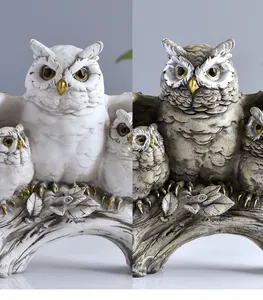 Side-by-side detail of vintage resin owl family sculptures in white and grey finishes