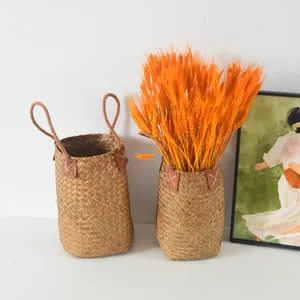 Detailed view of handwoven seagrass baskets with orange dried wheat in a Nordic style setting
