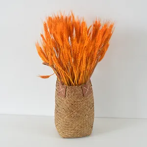Close-up of hand-woven seagrass basket featuring natural textures and orange wheat