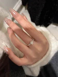 Elegante anillo torcido de plata S925 con piedra ovalada central y brillantes detalles de pavé.