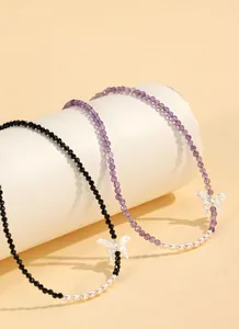 Close-up of beaded necklaces featuring freshwater pearls and silver butterfly charms