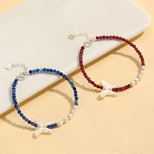 Close-up of crystal beaded bracelets with mother-of-pearl butterfly and freshwater pearls.