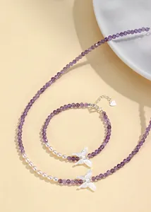 Close-up of amethyst and pearl jewelry set with elegant butterfly charm details