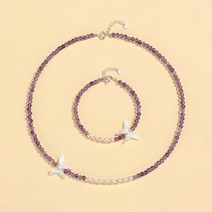 Detailed view of crystal and pearl jewelry set with elegant silver butterfly charms.