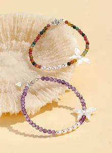 Elegant amethyst and freshwater pearl bracelet with white shell butterfly charm detail
