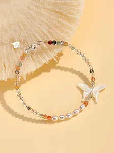 Detailed view of handmade beaded bracelet with butterfly pendant and freshwater pearls