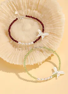 Close-up of handmade beaded bracelets with elegant butterfly charms and freshwater pearls