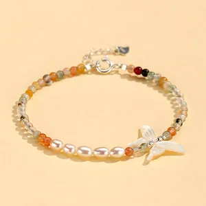 Detailed view of a New Chinese-style crystal and freshwater pearl butterfly charm bracelet