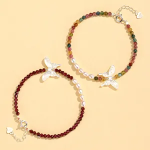 Two elegant handmade beaded bracelets with butterfly charms and natural pearls detail