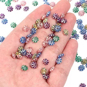Close-up detail of colorful plastic pumpkin spacer beads with silver plated edge for DIY crafts.