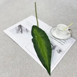 Close-up detail of artificial alocasia leaf showing realistic green texture and veins on scene.