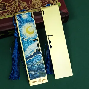 Close-up detail of metal bookmark featuring starry night art print and blue tassel.