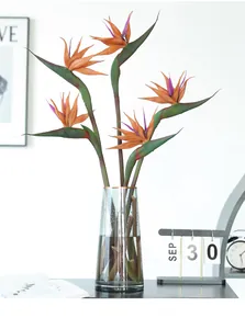 Lifelike artificial bird of paradise flower arrangement in sleek glass vase for home decor detail.