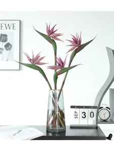 Large artificial bird of paradise flower arrangement in glass vase for modern home decor.