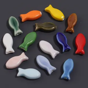 Colorful ceramic fish beads detail shot, smooth glazed surface, perfect for DIY jewelry making.
