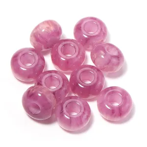 Close-up detail of pink marbled resin large hole loose beads with golden shimmer for DIY jewelry.