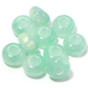 Close-up detail of light green resin beads with large holes, ideal for DIY jewelry crafting.