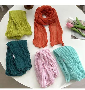 Detailed view of women long crinkled fashion scarves in vibrant candy colors, soft texture.
