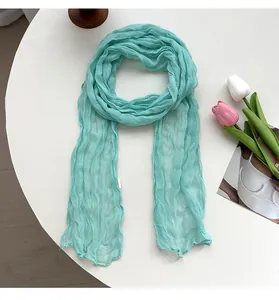 Detailed view of the mint green crinkled women scarf, showing delicate texture and soft fabric.