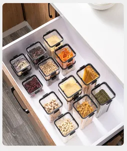 Contenitori trasparenti in plastica per alimenti ordinati in un cassetto della cucina.