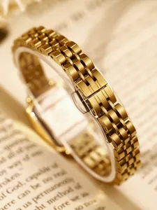 Macro detail shot of a luxurious vintage gold stainless steel jubilee watch bracelet on book pages