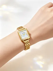 Close-up of elegant gold rectangular watch with mother of pearl dial on woman's wrist