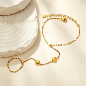 Vue détaillée d'un bracelet de doigt en acier inoxydable doré avec de jolis breloques cœur.
