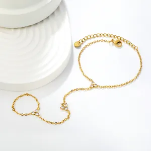 Vue détaillée d'un bracelet bague en acier doré avec breloques fleurs en zircon