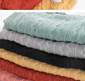 Detail of soft diamond-pattern knitted pet sweaters in various warm autumn colors