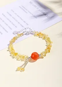 Dettaglio di un bracciale in frammenti di citrino naturale giallo con una perla di corniola